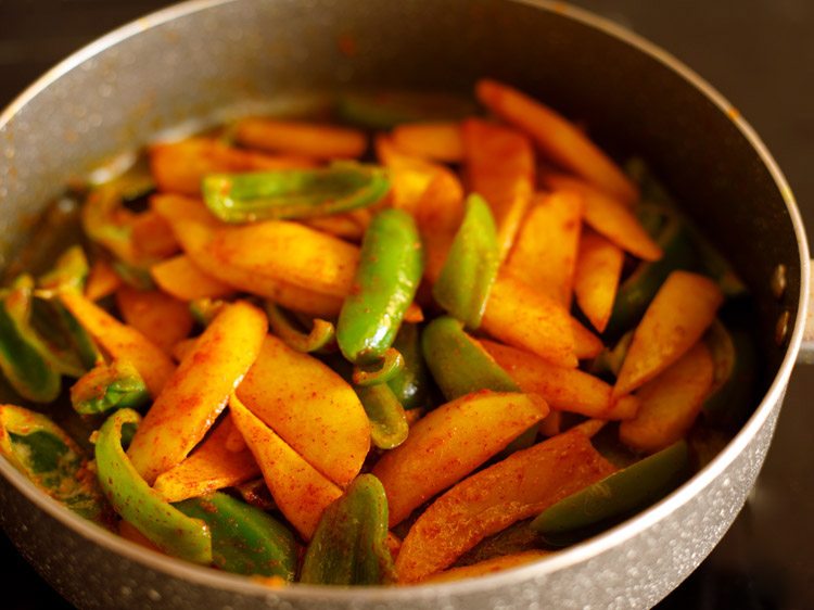 ground spices and salt mixed evenly with the potatoes and capsicum