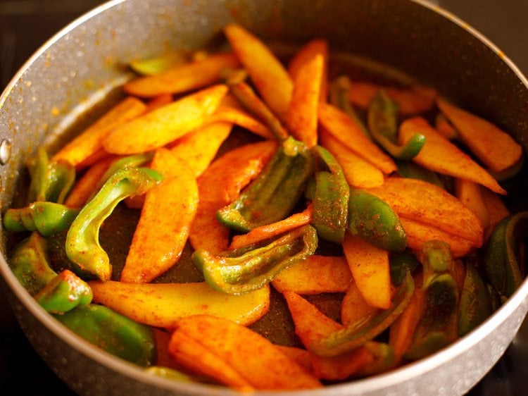 sautéing potatoes and capsicum further to make shimla mirch ki sabji