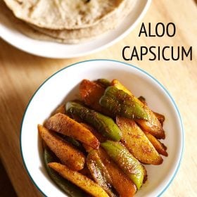 top shot of aloo capsicum or aloo shimla mirch ki sabji in a white green rimmed bowl on a beige colored wooden board