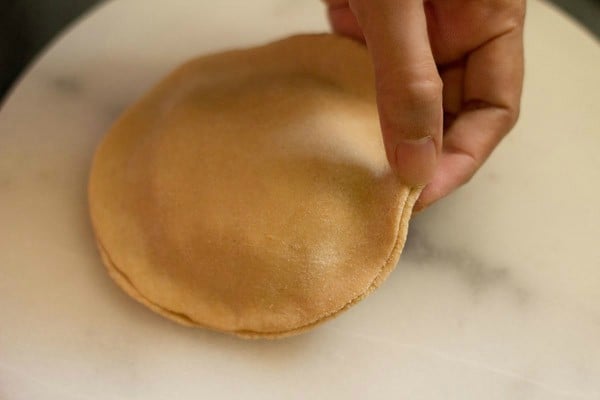 seal aloo paratha by pinching the two discs together.