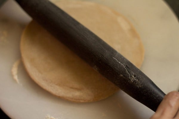 rolling aloo paratha after stuffing and pinching shut.