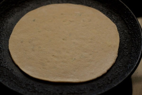 dry roasting aloo paratha on skillet.