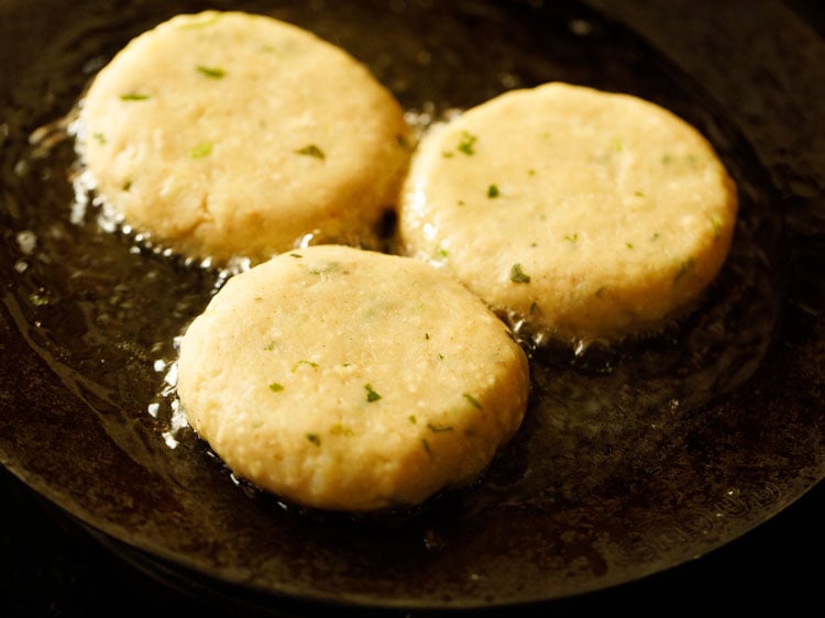 beginning to pan fry aloo tikki.