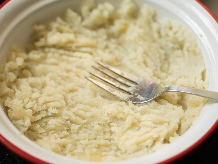 mashing potatoes in a bowl