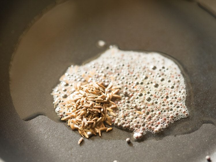 cumin seeds added to mustard seeds in oil
