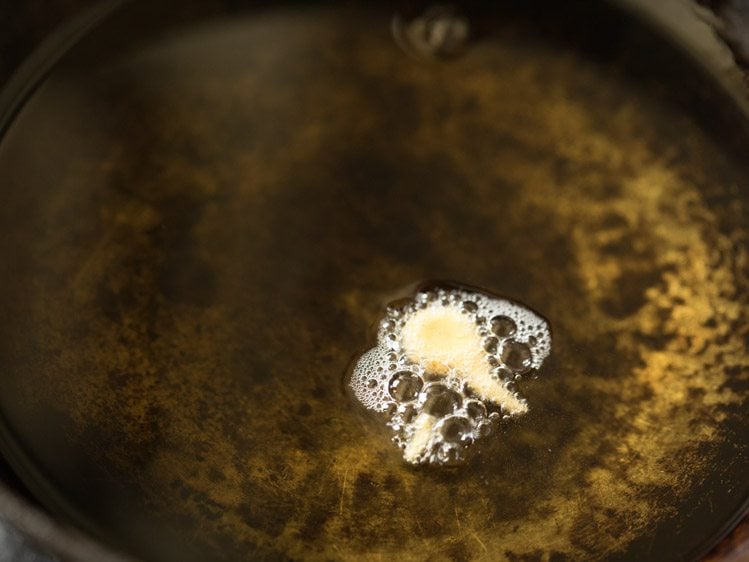 frying a tiny batata vada in oil