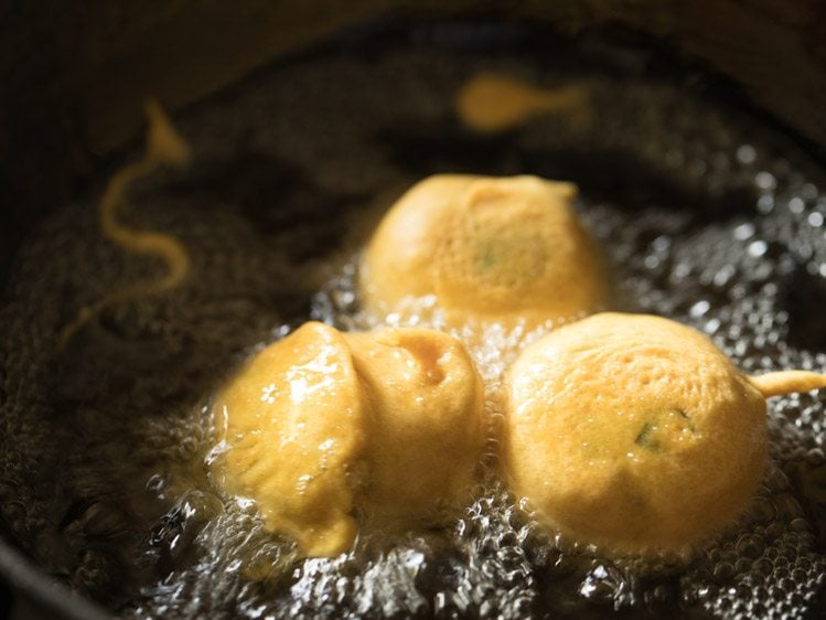 almost cooked batata vada in hot oil