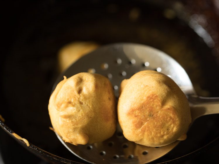 batata vada removed using a slotted spoon