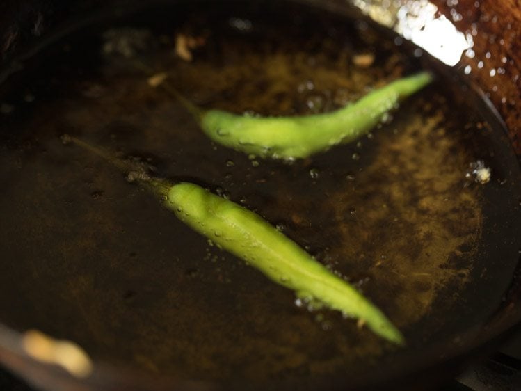 frying slit green chillies in hot oil