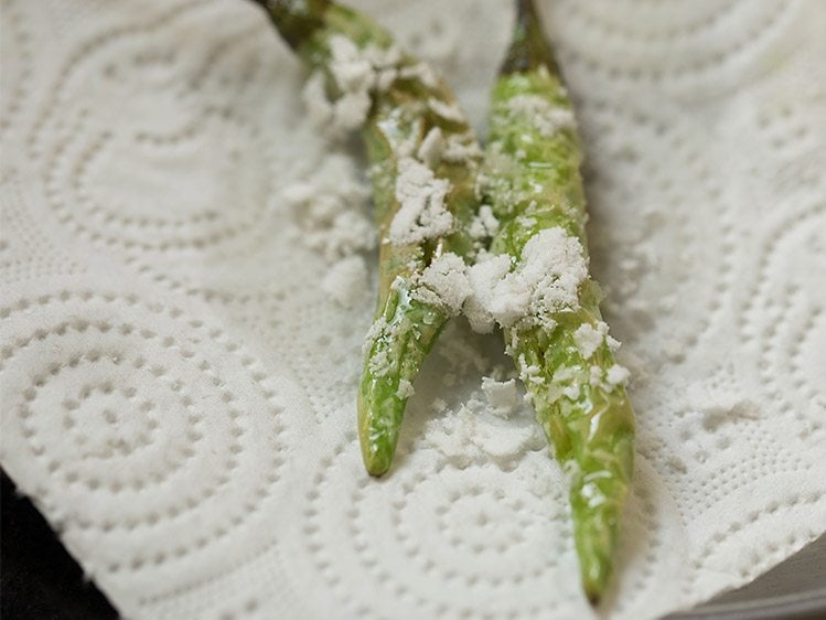 adding salt on green chillies in paper towels