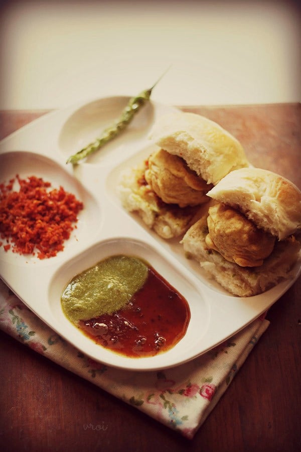 vada pav with green chilies, garlic chutney, green chutney and sweet chutney