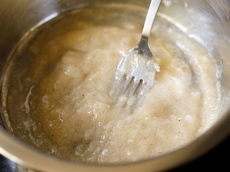mashed bananas and sugar in a bowl with a fork.