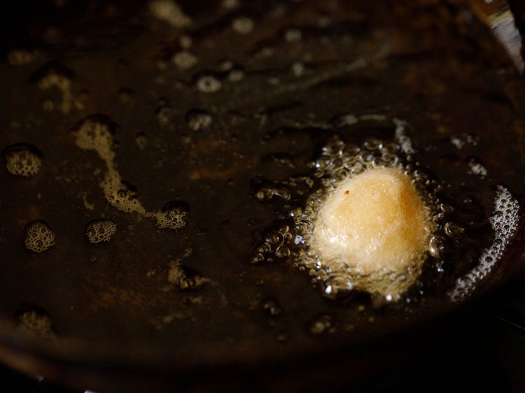 testing a small piece of gulgule in hot oil.