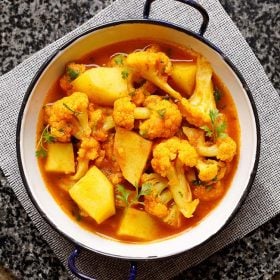 instant pot aloo gobi served in a small white wok on a grey jute mat