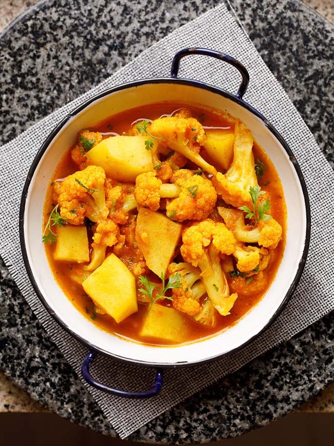 instant pot aloo gobi served in a small white wok on a grey jute mat