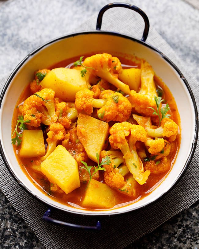 instant pot aloo gobi served in a small white wok on a grey jute mat