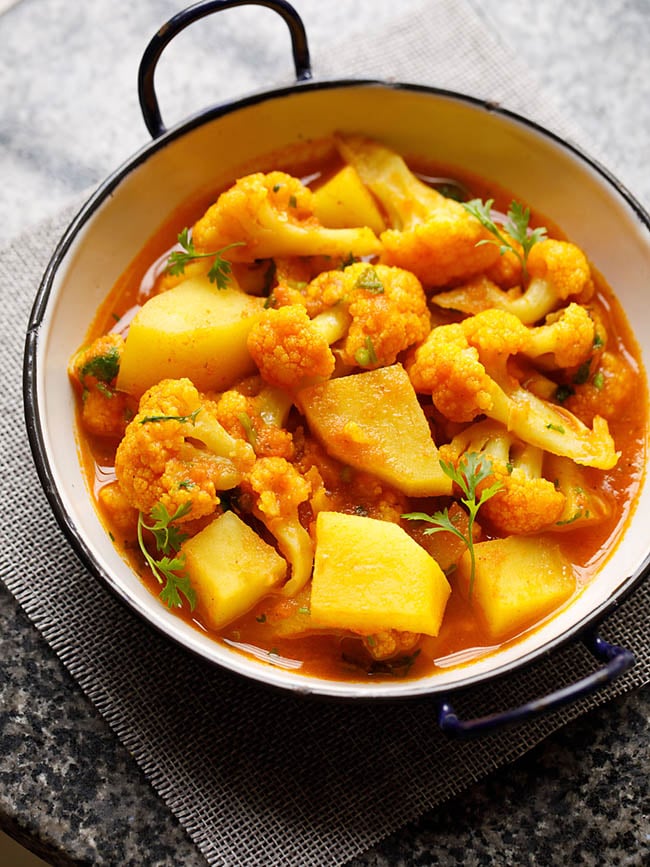 instant pot aloo gobi served in a small white wok on a grey jute mat