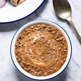 instant pot dal makhani served in a blue rimmed white bowl