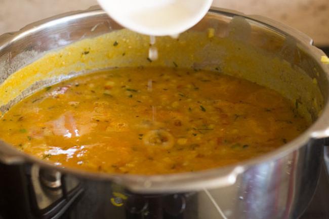 drops of lemon juice being added to moong dal fry