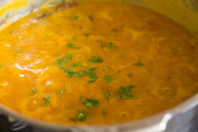 coriander leaves on moong dal fry in the cooker