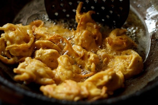 frying onion pakora in oil