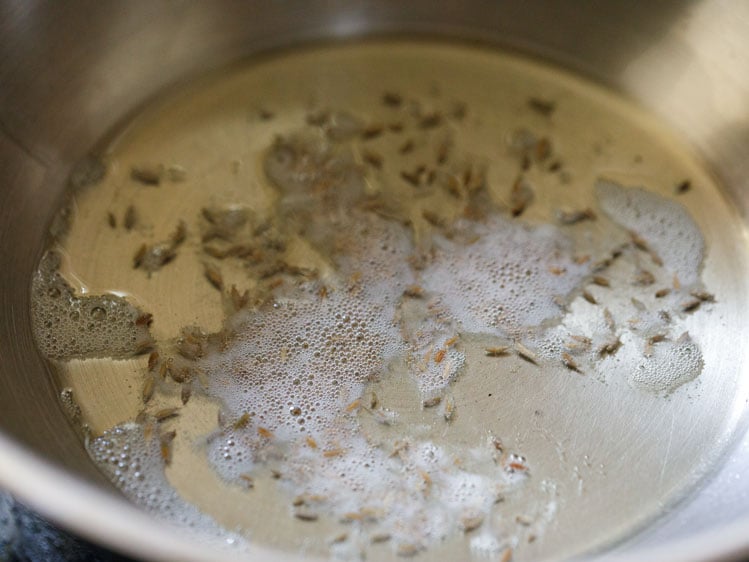 crackling cumin seeds in hot oil for paneer bhurji recipe. 