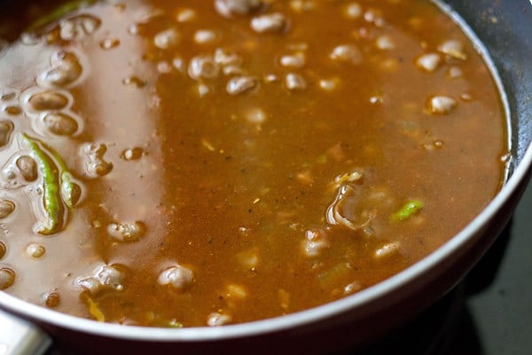 adding liquid to the chole for simmering into gravy