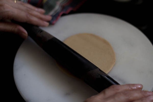 rolling poori with a french rolling pin.