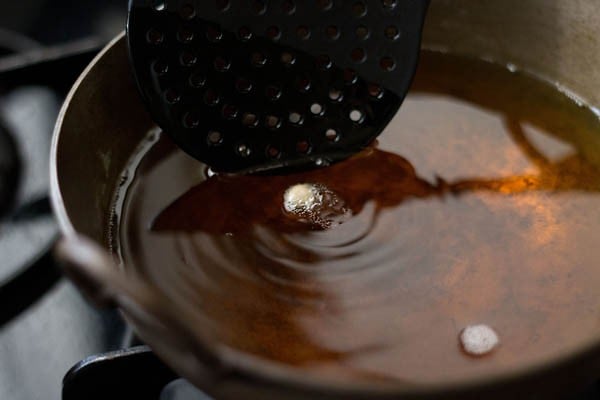 adding a poori to hot oil - it is bubbling.