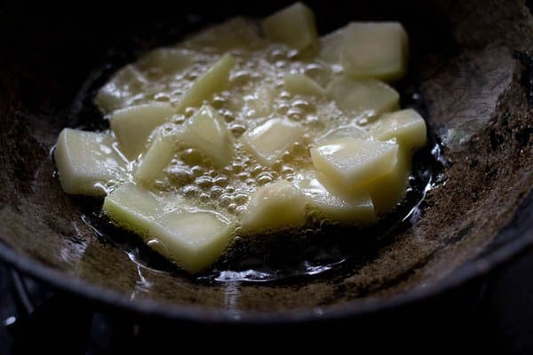 frying potatoes in oil in a kadai