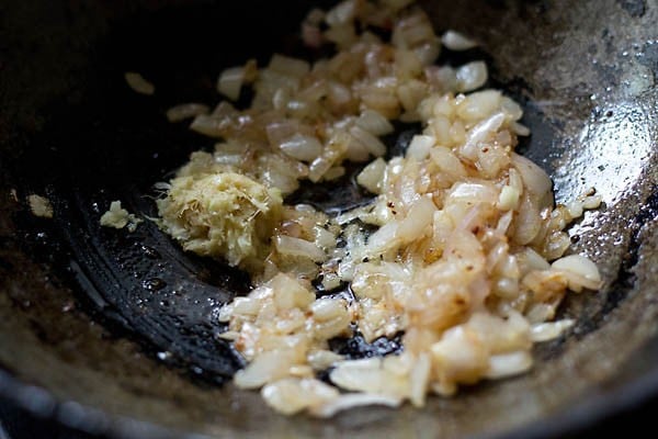 sauteing ginger garlic paste in a pan with onions