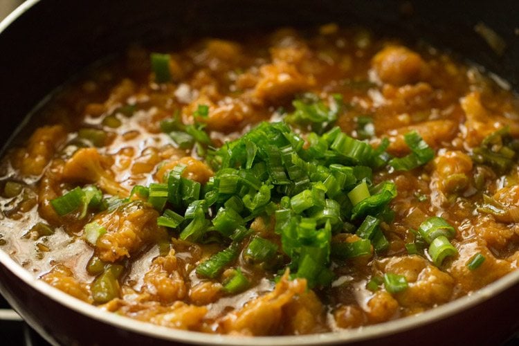 spring onion greens on top of gobi manchurian gravy