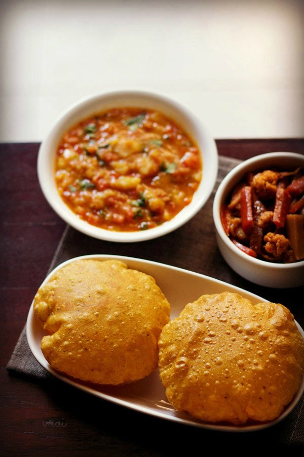 masala poori served in a plate with a side of potato curry and pickle