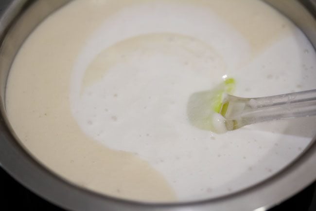 grinded rice added to bowl containing grinded lentils