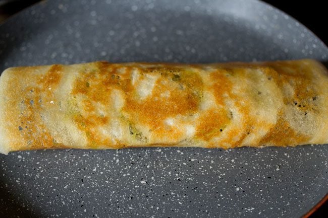 cooked and folded dosa on a skillet