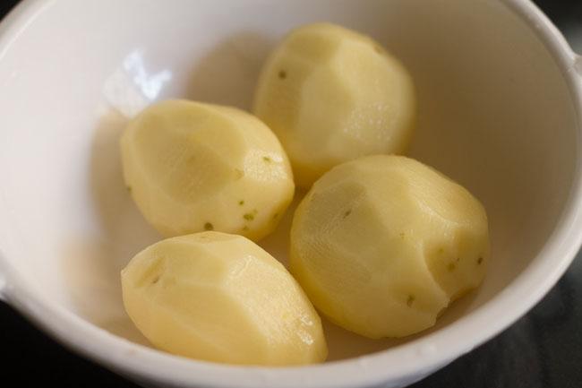 peeled potatoes in a white bowl