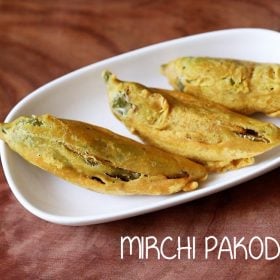 The mirchi pakoda is served on a white plate with text in the middle.