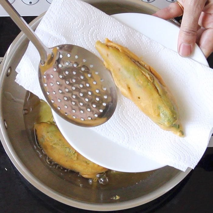 fried mirchi pakora placed on kitchen paper towels