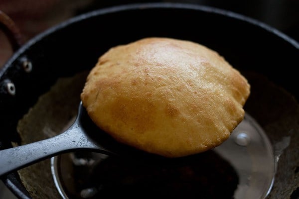 fried Mangalore buns on a slotted spoon