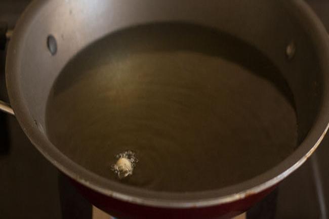 checking the temperature of hot oil to fry mix dal vada. 