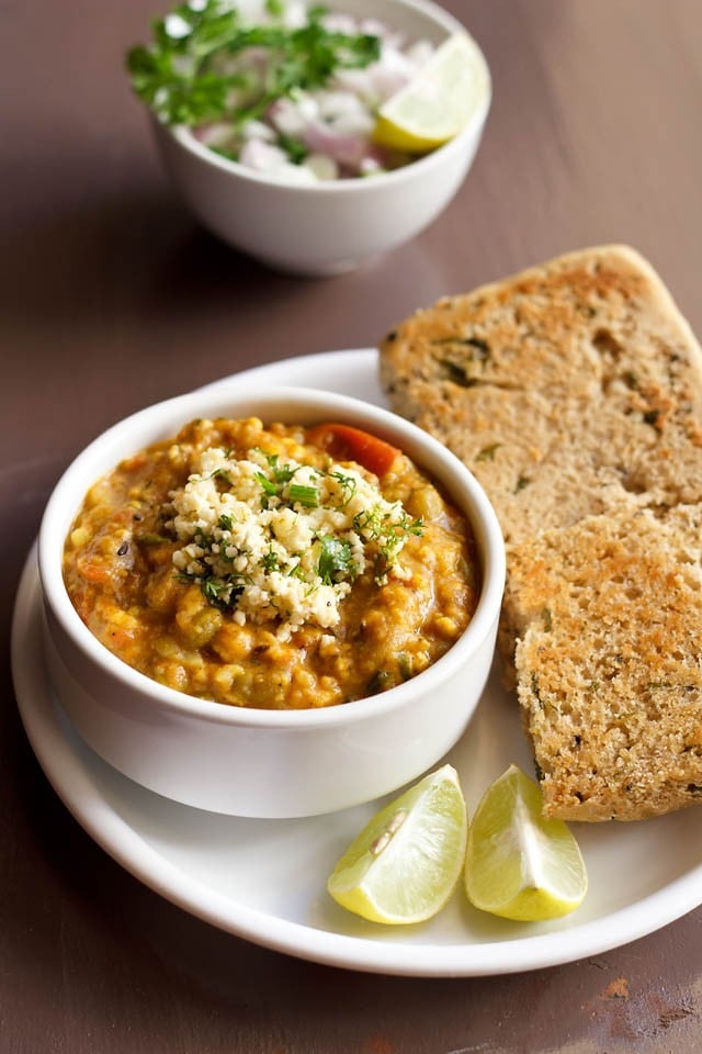 paneer pav bhaji served with pav and lemon wedge on a white plate.