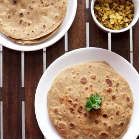 mooli paratha served on a white plate.