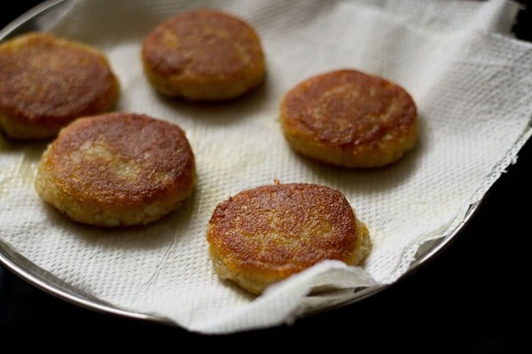 draining extra oil from the fried corn patties