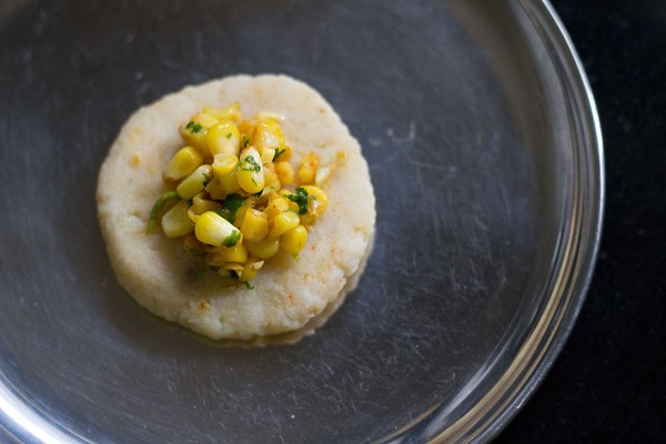 stuffing spiced corn placed in the center of flattened dough ball