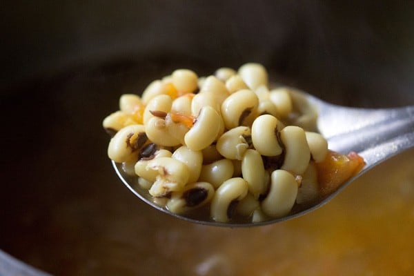 heap of cooked black eyed beans in a steel spoon