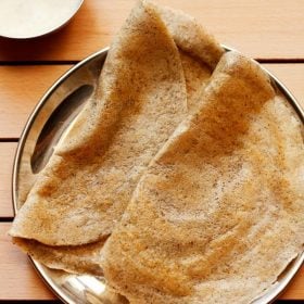 mix dal dosa served on a plate with a side of coconut chutney.
