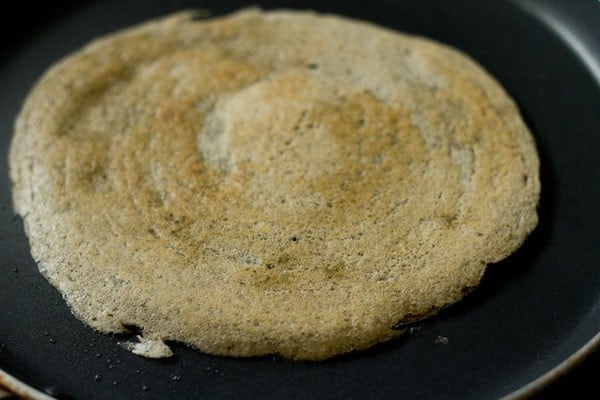 cooking mixed dal dosa on tawa