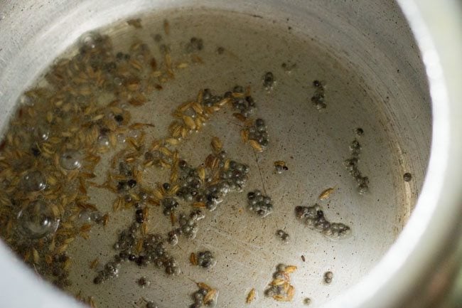 cumin seeds added to cooker for making tendli recipe. 