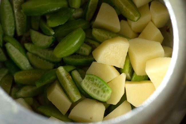 chopped tendli and potatoes added to cooker. 