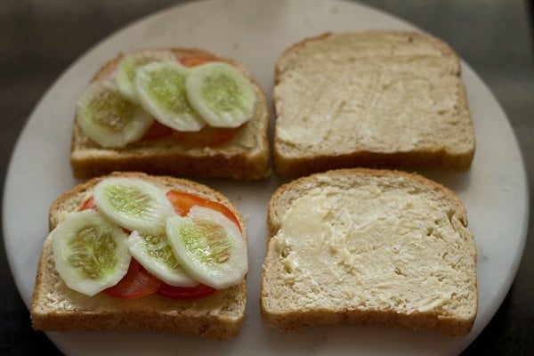 adding tomato and cucumber slices